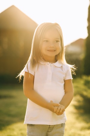 portrait of adorable smiling kid looking away on yardの写真素材