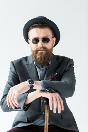 Man with vintage mustache and beard wearing hat and sunglasses isolated on light backgroundの写真素材