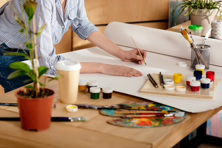 cropped shot of young female artist drawing on table in studioの写真素材