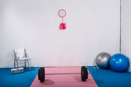 barbell, boxing gloves, fit balls and tape recorder in gymの写真素材