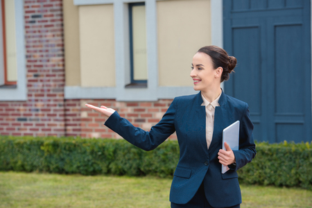 beautiful businesswoman showing something and looking awayの写真素材