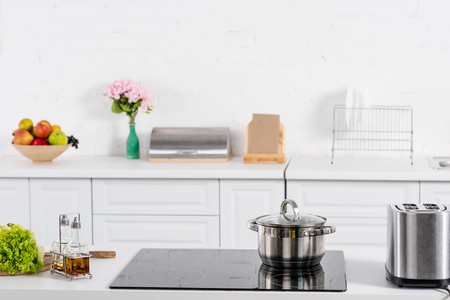 toaster and electric stove with saucepan on kitchenの写真素材