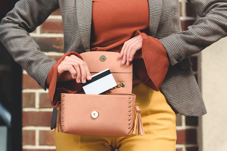 cropped image of stylish woman taking credit card from handbagの写真素材