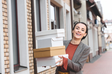laughing attractive woman holding shopping boxesの写真素材