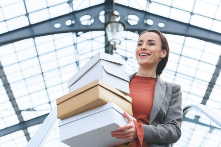 low angle view of attractive woman holding shopping boxes