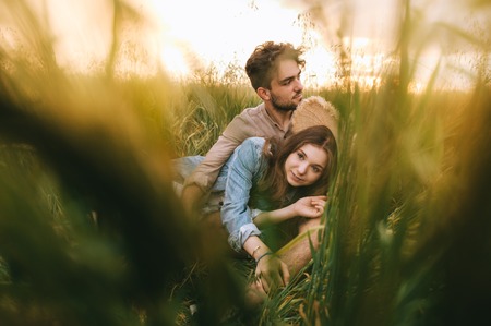 beautiful couple hugging in green grass on meadow, selective focusの写真素材