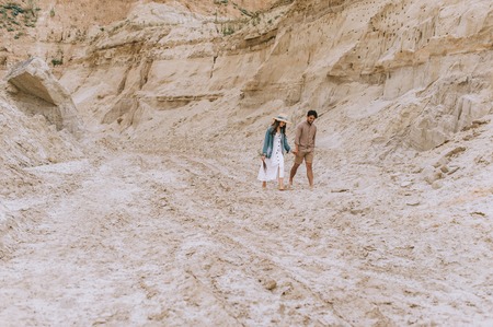 beautiful couple holding hands and walking in sand canyonの写真素材
