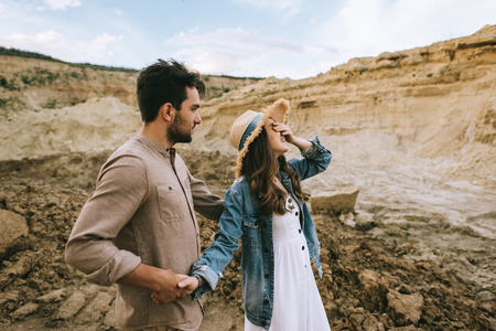 laughing girl closing eyes and holding hands with in sand canyon