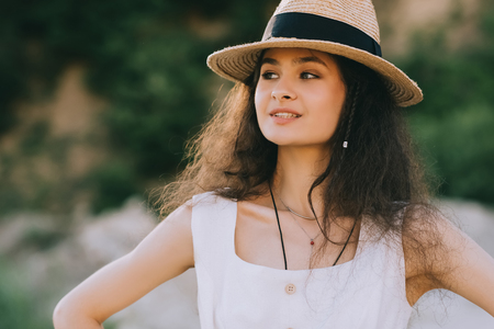 beautiful curly girl posing in straw hatの写真素材