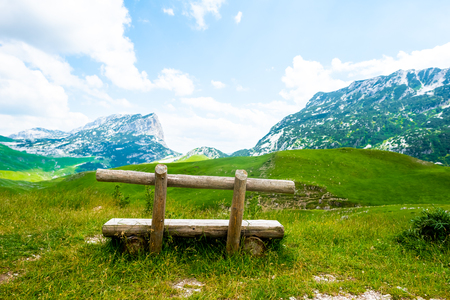 wooden bench with beautiful mountains in Durmitor massif, Montenegroの写真素材