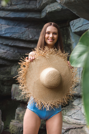 beautiful smiling woman in straw hat in tropical gardenの写真素材