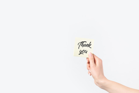 partial view of woman holding thank you card isolated on whiteの写真素材
