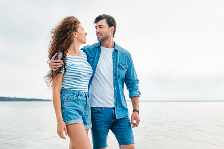 happy young couple embracing on beach near seaの写真素材