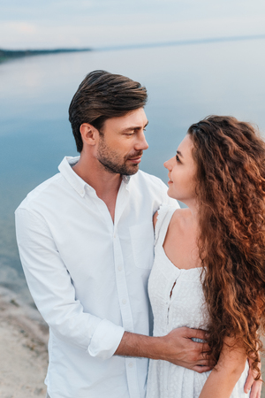 young romantic couple looking at each other and embracing on beachの写真素材