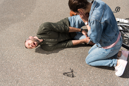 driver looking at screaming biker after car accident on roadの写真素材