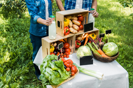 cropped image of couple of farmers setting stall at farmer marketの写真素材