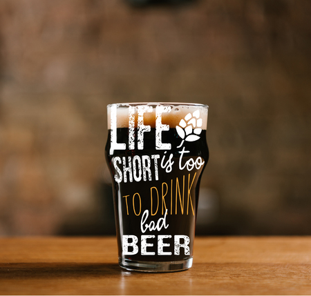glass of fresh cold dark beer on wooden table in pub with "life is too short to drink cheap beer" inspirationの写真素材