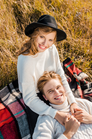 happy young couple looking at camera on rural meadowの写真素材