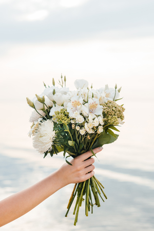 cropped view of woman holding beautiful bouquet with white flowersの写真素材