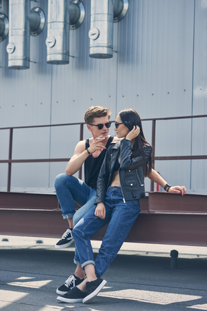 stylish multicultural couple smoking cigarette togetherの写真素材