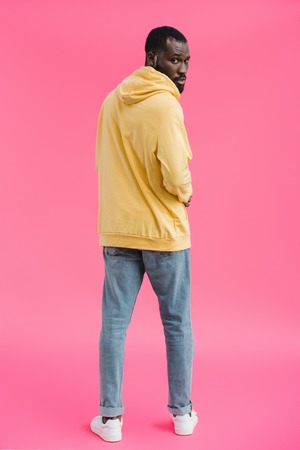 stylish african american man looking at camera on pink background