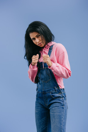 confident angry african american woman in fight position isolated on blue backgroundの写真素材