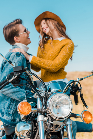 happy couple looking at each other and sitting on motorbikeの写真素材