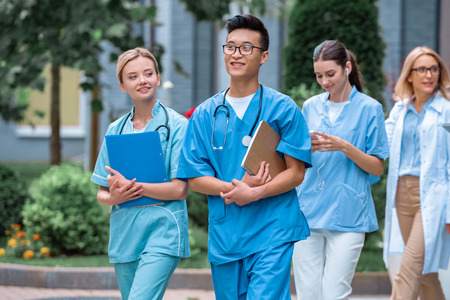 multicultural students and teacher walking on street near medical universityの写真素材