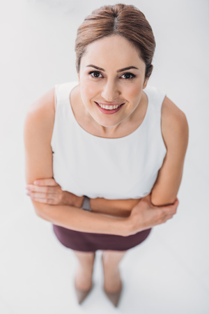 top view of adult smiling businesswoman looking at camera on whiteの写真素材