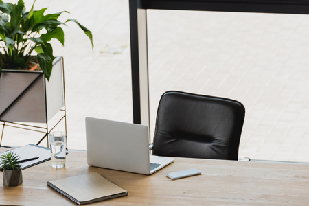 laptop and smartphone on wooden table in modern officeの写真素材