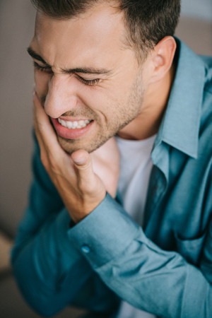 close-up view of young man suffering from toothacheの写真素材