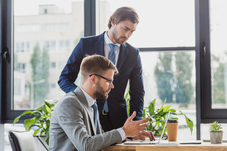 focused young businessmen using laptop while working together in officeの写真素材
