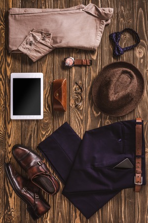 flat lay with stylish male clothing, hat, shoes and accessories arranged on wooden tabletopの写真素材