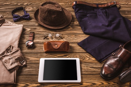 close up view of male accessories, stylish clothing and tablet on wooden tabletopの写真素材