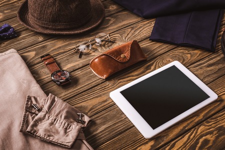 close up view of male accessories, stylish clothing and tablet on wooden tabletopの写真素材