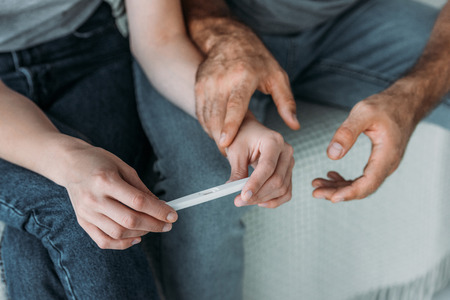 cropped shot of unhappy couple holding pregnancy testの写真素材