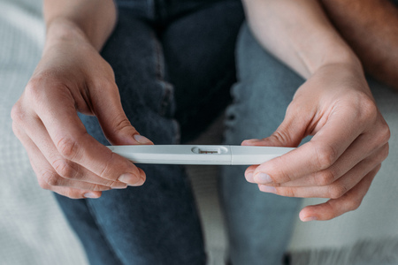 close-up partial view of couple holding pregnancy testの写真素材
