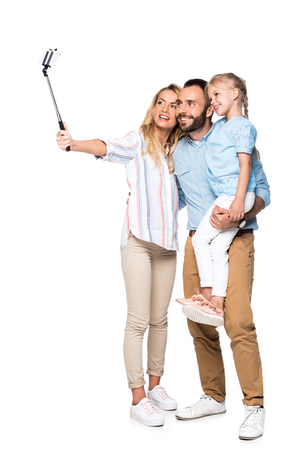 smiling family taking selfie on smartphone isolated on whiteの写真素材