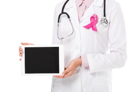 cropped shot of doctor with pink ribbon holding digital tablet with blank screen isolated on white, breast cancer awareness conceptの写真素材