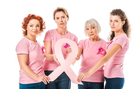 women in pink t-shirts holding breast cancer awareness ribbon and looking at camera isolated on whiteの写真素材