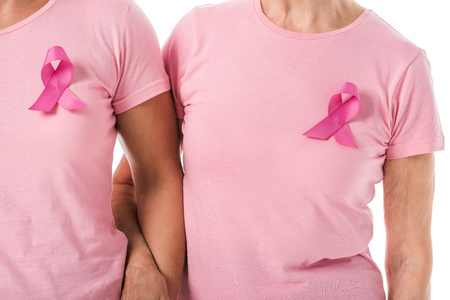 cropped shot of women with pink ribbons holding hands isolated on white, breast cancer awareness conceptの写真素材
