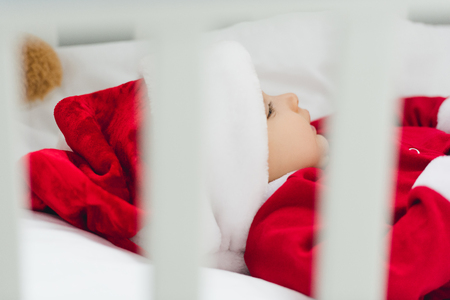 close-up shot of little baby in santa suit lying in infant bedの写真素材