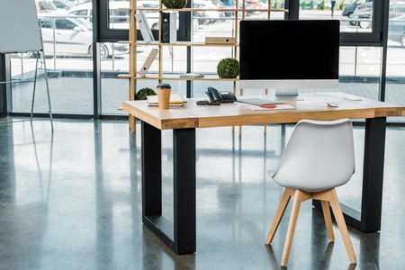 close up view of workplace with blank computer screen in office