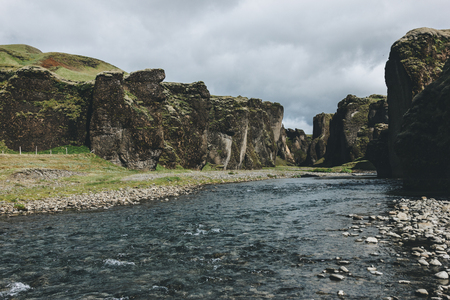 scenic view of beautiful mountain river flowing through highlands in Fjadrargljufur Canyon in Icelandの写真素材