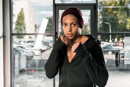 confident african american boxer standing in fight position at gymの写真素材