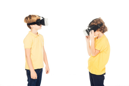 cute little boys using virtual reality headsets isolated on whiteの写真素材