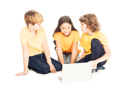 cute smiling kids using laptop together isolated on whiteの写真素材