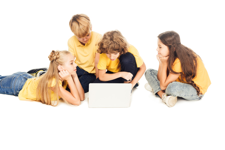 group of adorable children using laptop together isolated on whiteの写真素材
