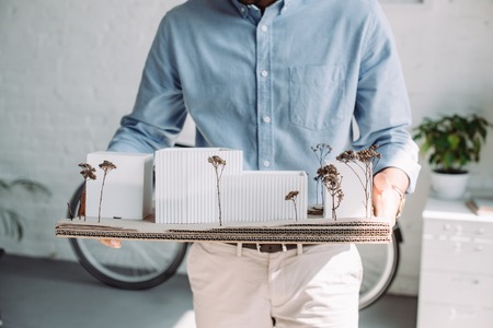 cropped image of architect holding architecture model in office