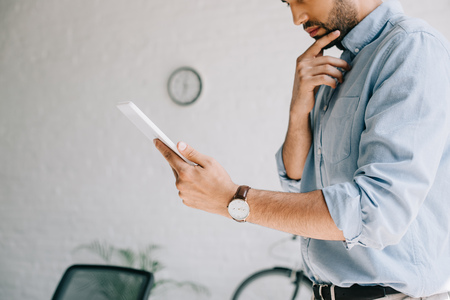 cropped image of pensive architect using tablet in office